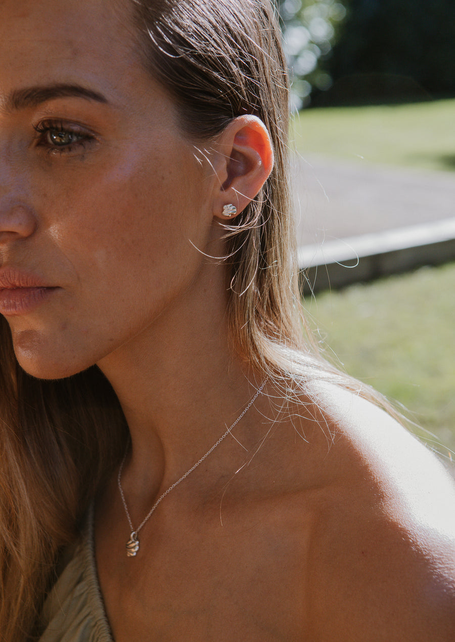 shell fragment earrings on model, in sunlight.